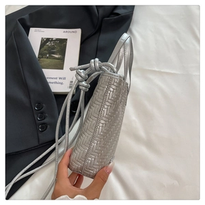 Détail du sac à bandoulière tressé argenté avec sangle et nœud décoratif