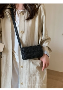 Detail shot of the woven black crossbody bag with iconic FF logo and textured finish