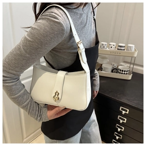 Détail du sac bandoulière en cuir blanc avec un fermoir vintage doré en forme de gourde