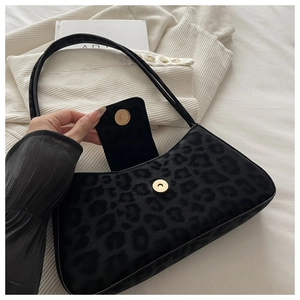 Nahaufnahme der schwarzen Handtasche mit Leopardenmuster, Magnetverschluss und Schultergurt