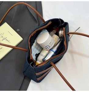 Vue de dessus d'un sac cabas en jean montrant l'intérieur spacieux rempli de cosmétiques