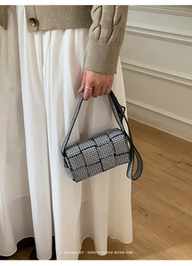 Detail of a chic black and white geometric patterned small square bag with shoulder strap
