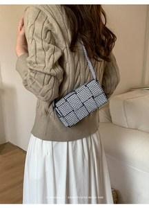 Minimalist shoulder bag featuring black and white woven geometric pattern on model