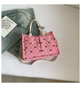 Detail of pink corduroy tote bag with black bow lattice pattern and front pockets
