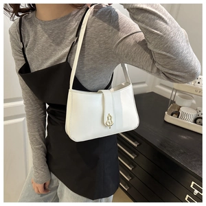 Détail d'un sac baguette en similicuir blanc avec un fermoir doré en forme de gourde