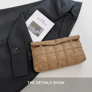 Close-up of quilted khaki envelope clutch featuring gold hardware and stitched grid pattern