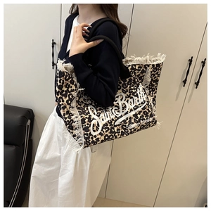 Close-up of leopard print canvas tote with fringe edges and Saint Barth lettering