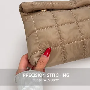 Close-up of khaki quilted puffy handbag showing premium stitching and gold metal buckle