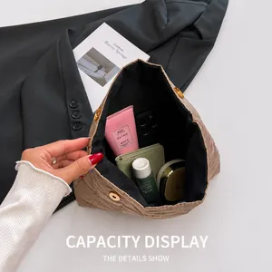 Quilted khaki clutch bag showing spacious interior with skincare and metal magnetic closure