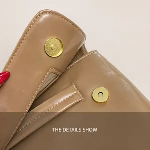 Detail of khaki leather handbag featuring a golden magnetic snap and neat stitching