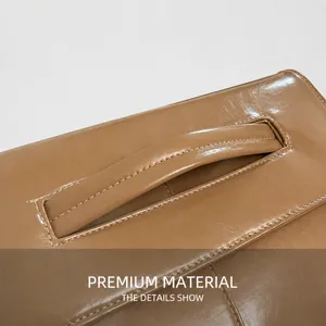 Close-up of tan leather handle showing premium stitching and textured grain on the bag
