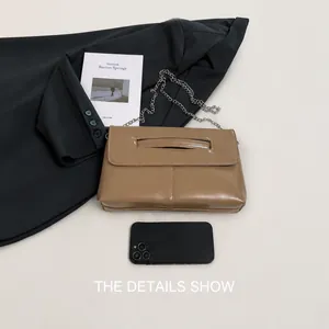 Detailed view of brown leather bag interior capacity with smartphone size reference