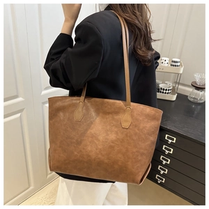 Borsa tote marrone indossata a spalla in interni minimalisti per mostrare la dimensione