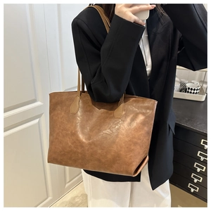 Dettaglio ravvicinato della borsa tote vintage in pelle PU marrone con trama effetto invecchiato