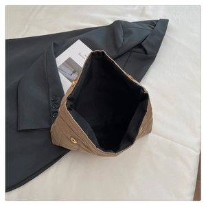 Detail of khaki quilted cotton tote with golden magnetic closure and large interior capacity