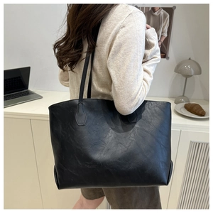 Dettaglio di una grande borsa tote in pelle nera con trama fine e stile moderno minimalista