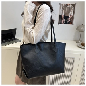 Grande borsa tote vintage in ecopelle nera mostrata in un ambiente interno da ufficio