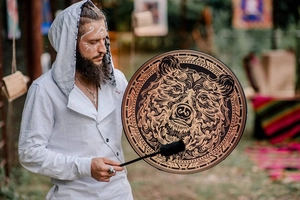 Close-up of Shamanic frame drum with brown bear totem and black plush drumstick