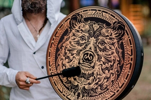 Detail of handmade Siberian Shaman drum featuring a brown bear and tribal geometric patterns