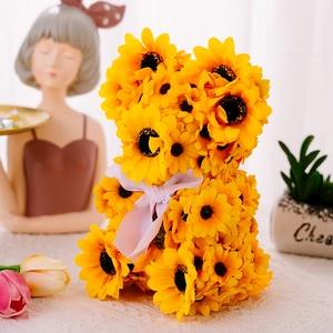 Detailed view of sunflower teddy bear ornament with white ribbon and decorative background