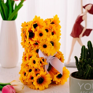 Detailed view of a sunflower bear figurine featuring a white ribbon and floral home decor
