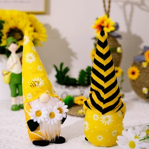 Detail of bee and daisy themed gnomes with white beards and sunflower decor