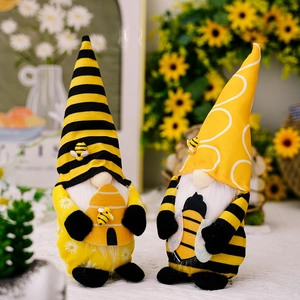 Close-up of plush bumble bee gnomes with yellow stripes, sunflowers, and soft white beards