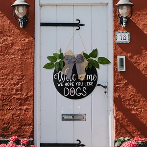 Close-up of rustic welcome door hanger with dog theme text and burlap bow decoration