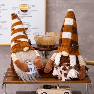 Detail of knitted coffee gnomes with white beard and braided hair on a wooden shelf