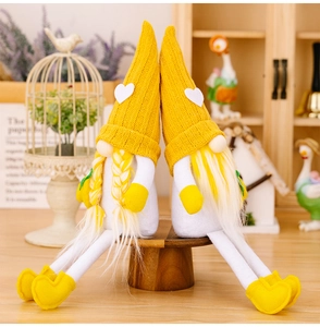 Detail of yellow knitted long-legged lemon gnomes on a wooden stand for home decor