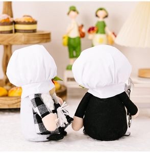 Vue arrière de figurines de gnomes cuisiniers avec toques et tabliers à carreaux en cuisine
