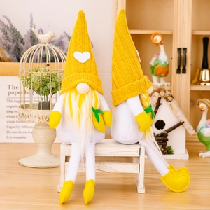 Pair of yellow knit summer gnomes with long legs and lemon-themed decor on a wooden bench