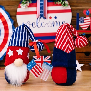 Patriotic gnome dolls with American flag stripes and stars on a festive wooden backdrop