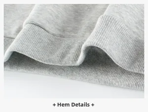Detailed macro view of the ribbed hem on a loose gray fleece knit sweatshirt