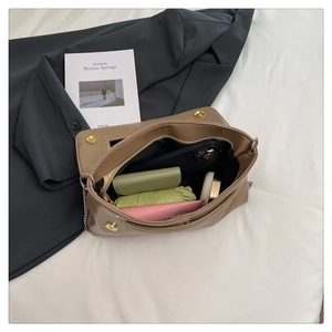 Interior view of brown leather clutch showing ample storage for phone and daily items