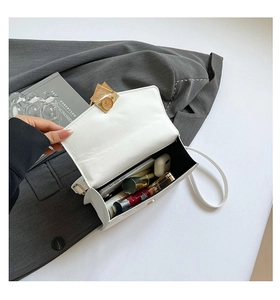 Interior detail of white quilted crossbody bag showing space for phone and cosmetics