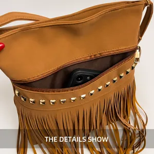 Detail view of brown crossbody bag showing front zipper pocket with rivets and tassels