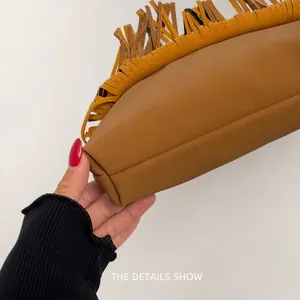 Detail of tan suede fringe and precision stitching on large crossbody shoulder bag