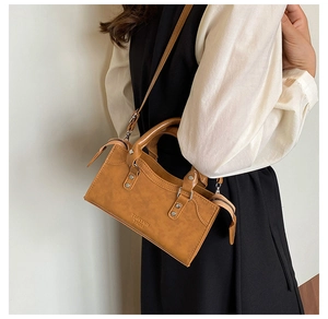 Detail showing vintage brown PU leather texture with silver rivets and dual handles