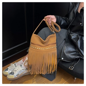 Detail of brown faux leather shoulder bag featuring gold studs and long fringe tassels