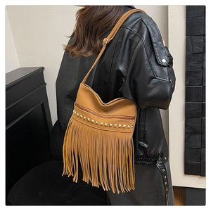 Detail view of brown tassel shoulder bag with metallic rivets on leather material