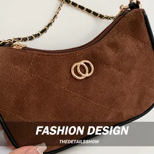 Macro shot of brown quilted suede shoulder bag with gold hardware and chain strap details