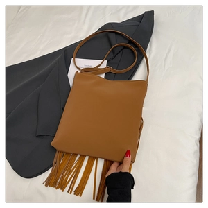 Close-up of brown fringe shoulder bag featuring long tassels and adjustable strap