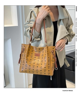 Detail of the chic brown tote bag with bear pattern print and golden hardware on the strap