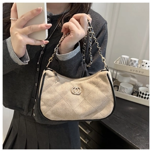 Detailed macro of beige quilted suede shoulder bag with golden chain and ring logo