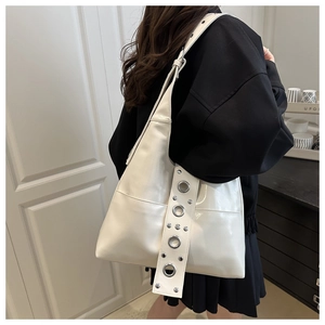 Detail of white punk tote bag featuring large silver metal eyelets and rivets on straps