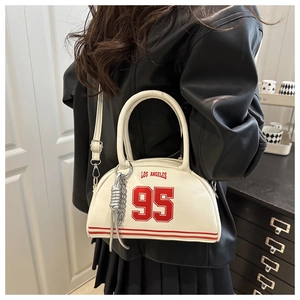 Detail of white leather crescent bag featuring red Los Angeles 95 varsity print and charms
