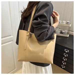 Dettaglio della borsa tote crema con fibbia in metallo e scritta Fashion & Bags