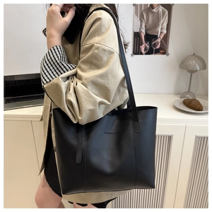 Close-up of the black tote bag featuring a Fashion & Bags embossed logo on matte leather