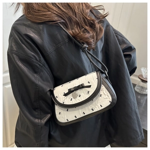 Détail du petit sac noir et blanc avec broderie K et pendentif en forme de cœur